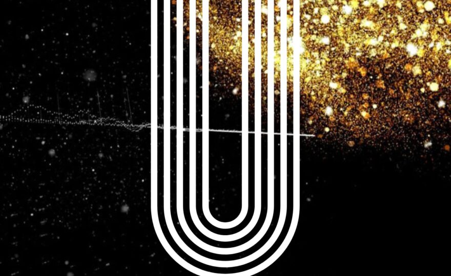 Ett stort U i vitt och glitter bakom.