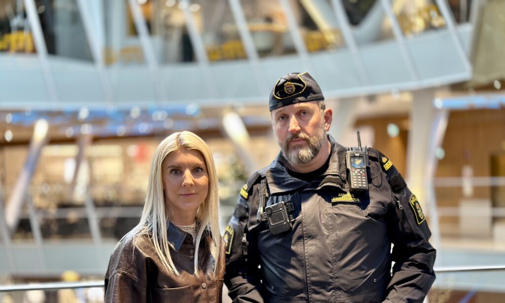 Sandra Linder, marknadsansvarig kvarteret Utopia står bredvid polisen Andreas. I bakgrunden ser man gallerians atrium.